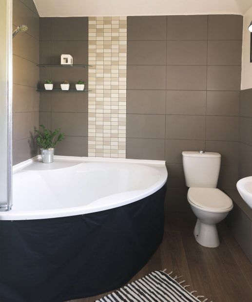 A corner bath in a small bathroom takes up the ignored space